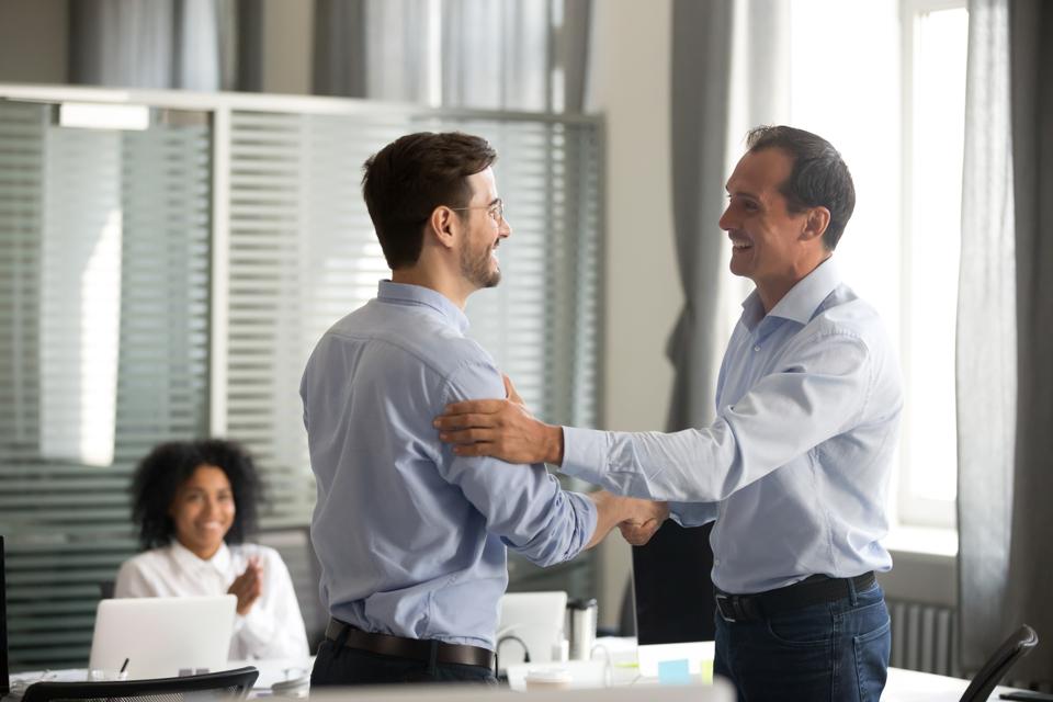 Business men shaking hands and smiling.