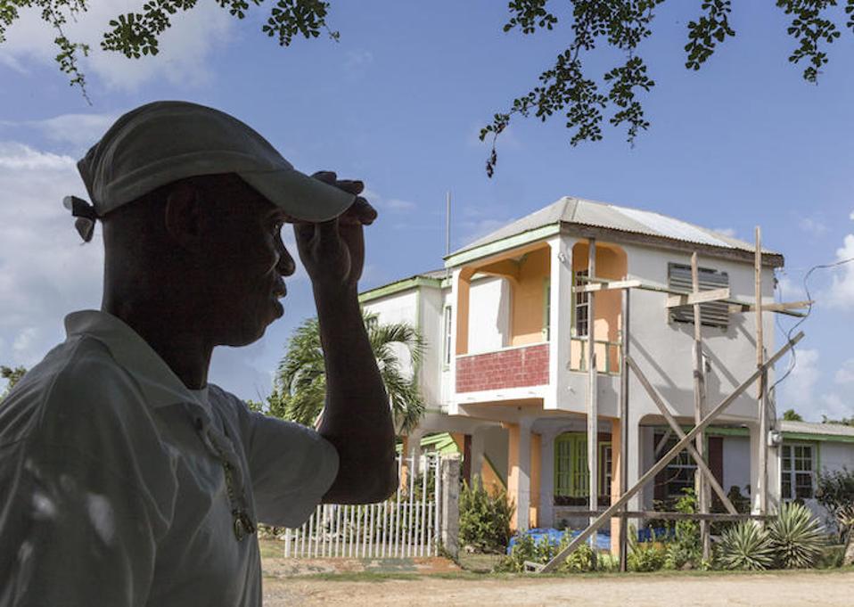 On the island of Barbuda, James Gerald, Sr. stands in front of his family's home, damaged by Hurricane Irma. He looks forward to being reunited with his wife and children one day. ″I'd like to be there for them as a father, every day,″ he says.