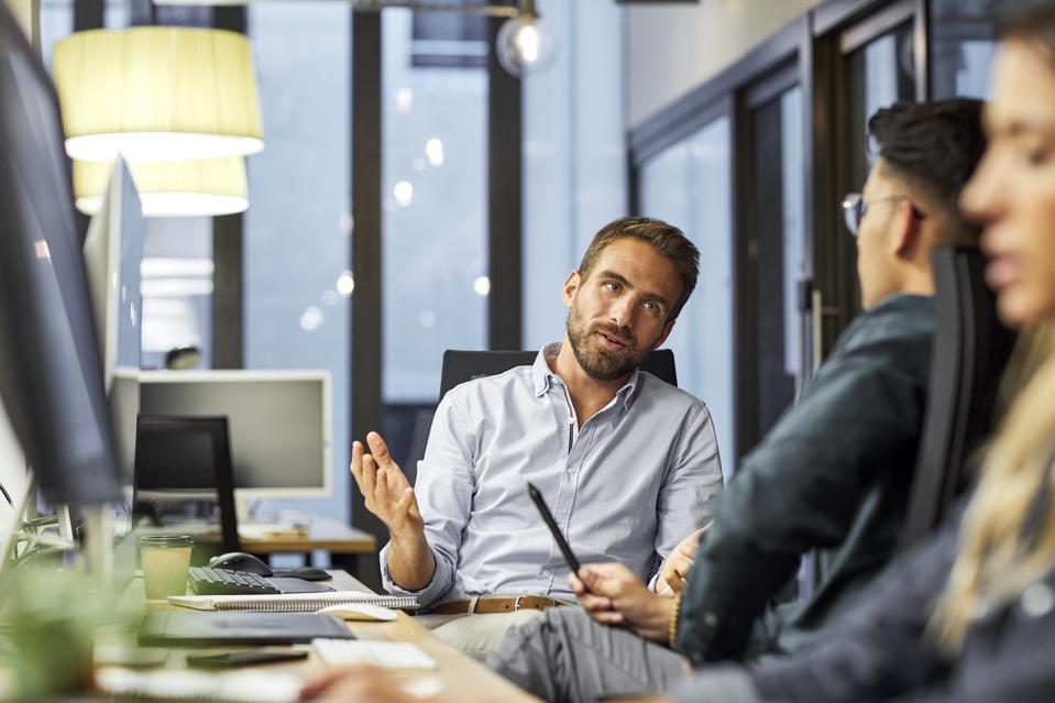 Male coworkers discussing during meeting in office