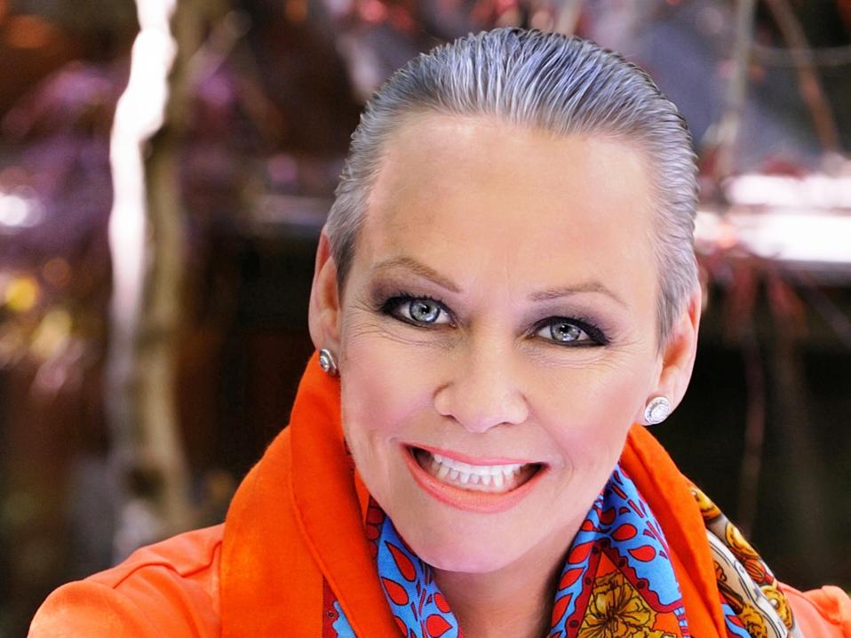 Headshot of Jordan in an orange shirt and blue scarf.