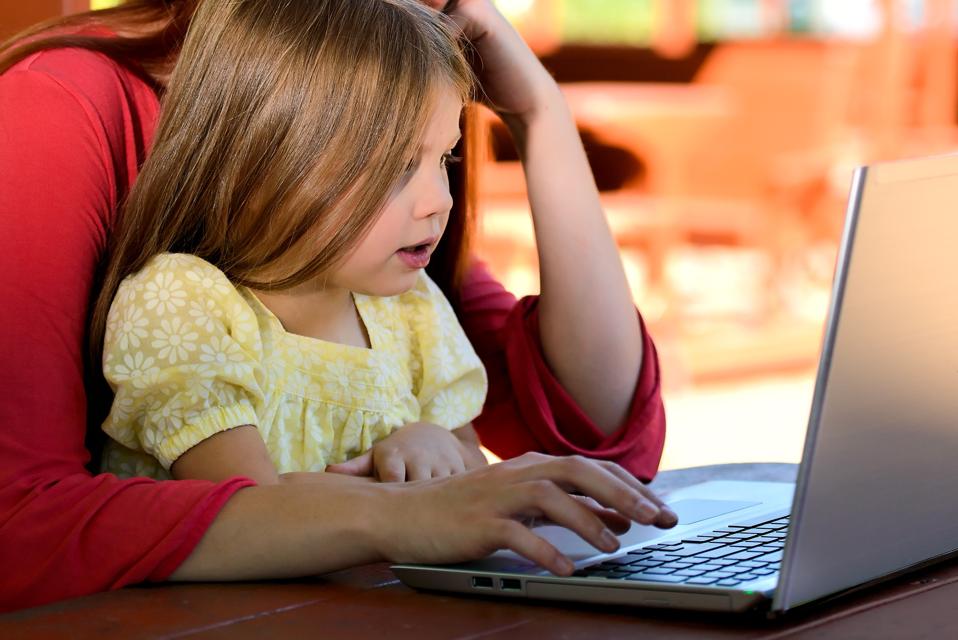 Mother and girl learning together on the computer