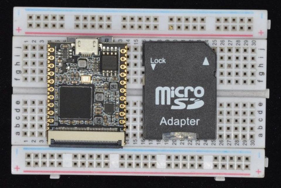 The AllWinner F1C100s, next to a MicroSD adapter for scale.