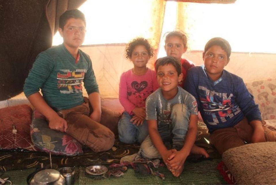 Hasan, 8, front and center, and his four siblings live in a camp for displaced persons in northern Idlib, Syria, one of many camps where a self-learning program, created by UNICEF in partnership with Educate A Child, is helping out-of-school kids.