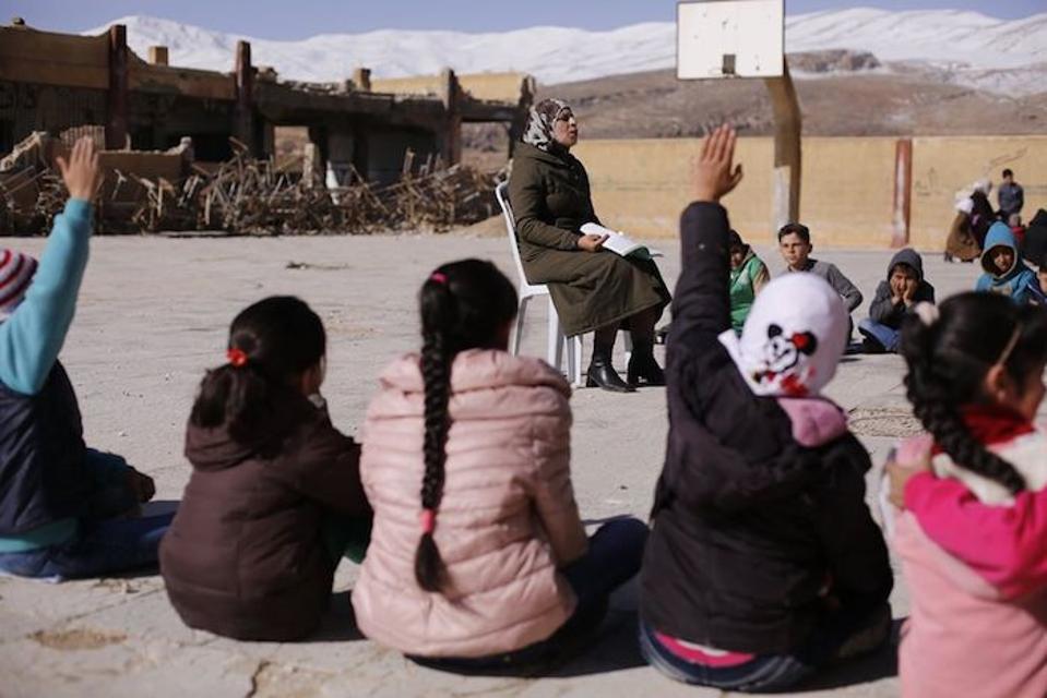 A self-learning class is held outside a damaged school building in Beit Jinn, a town in rural Damascus. The curriculum is specially designed for students who have been out of school for some time.