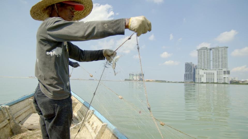 Portuguese fisherman with new development areas and Melaka Gateway in the background.