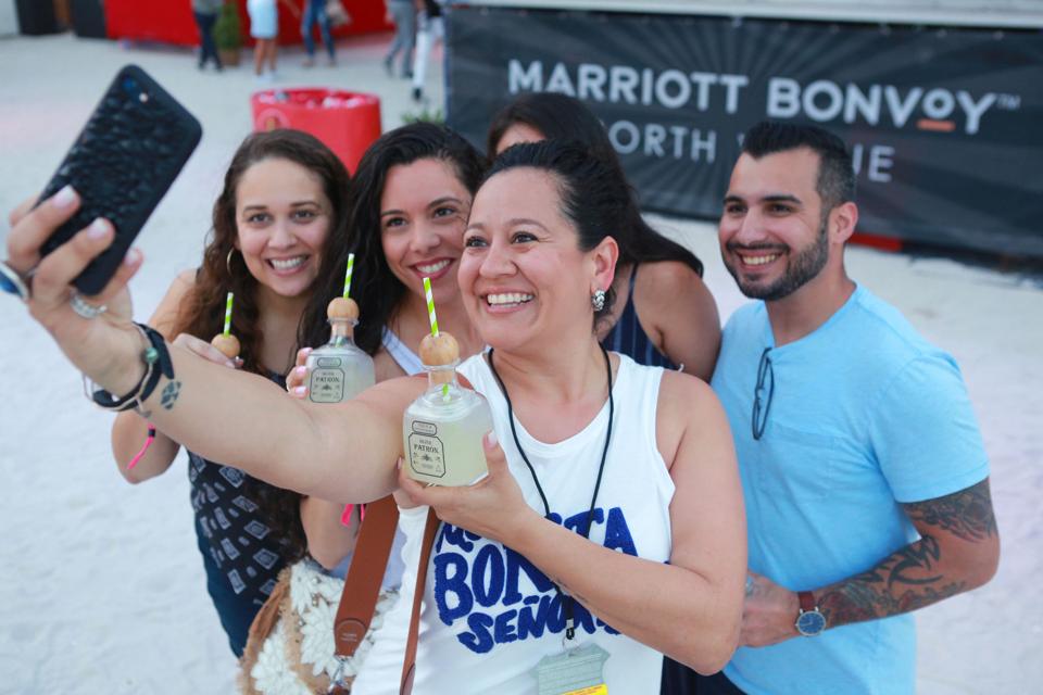A group of people taking a selfie, with drinks in hand.