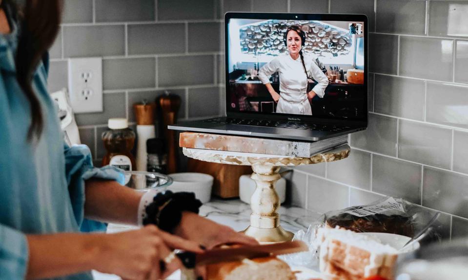 A pastry chef teaches a client on a laptop