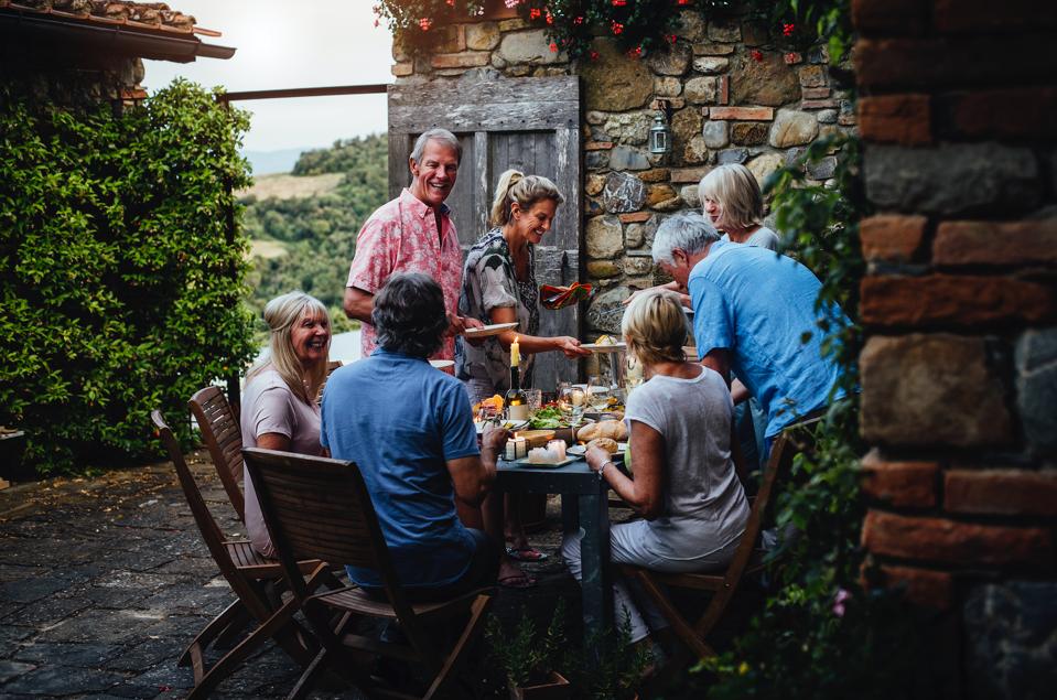 A family dines outside at a house swapped through Home Exchange