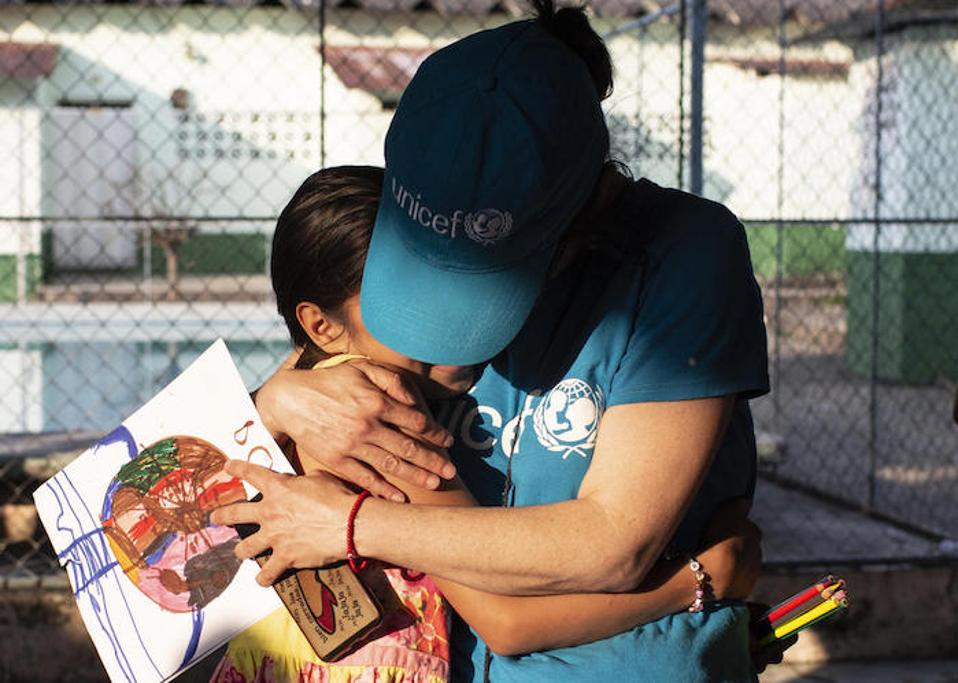 In Mexico, a UNICEF volunteer hugs a 10-year-old girl whose mother was murdered by gang members in San Pedro Sula, Honduras. She and her older siblings traveled north, hoping to find safety in the United States.