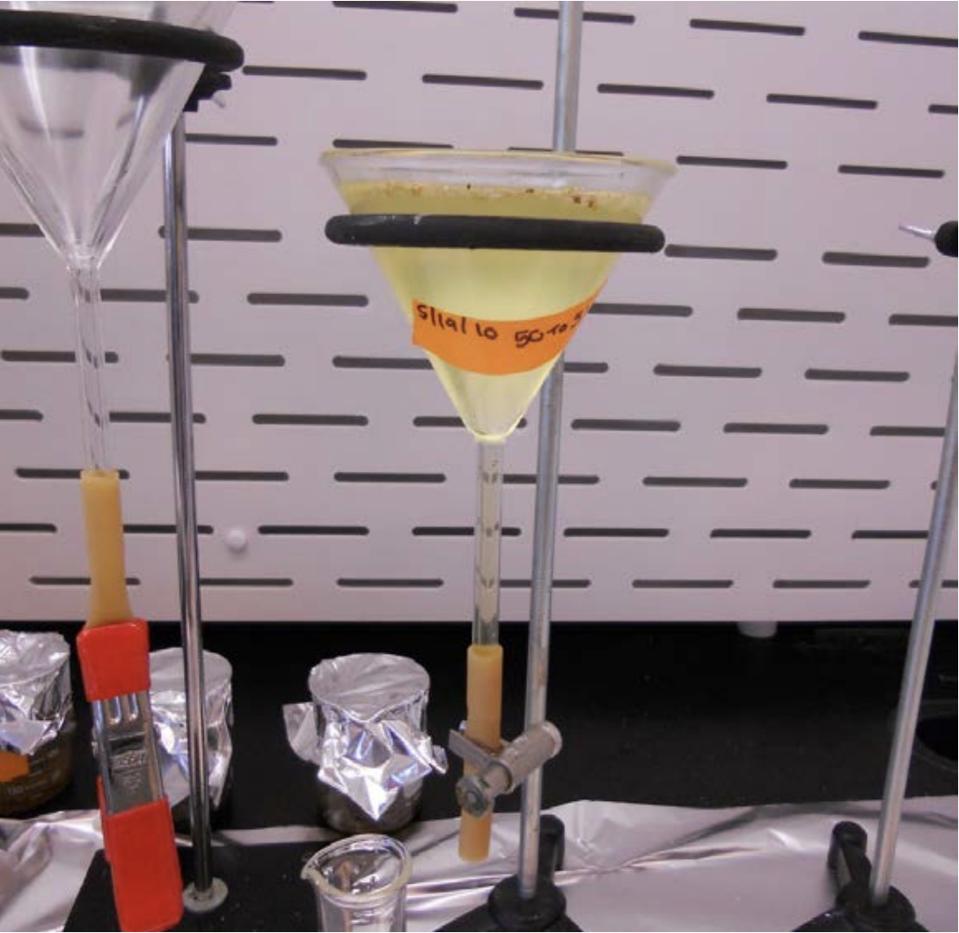 A funnel with a yellow peroxide solution for separating microplastics out of water.