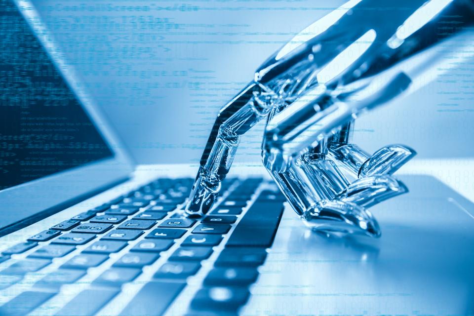 Robot hand typing computer keyboard