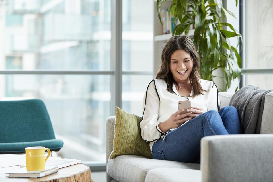 A relaxed woman holds chats on her mobile phone.