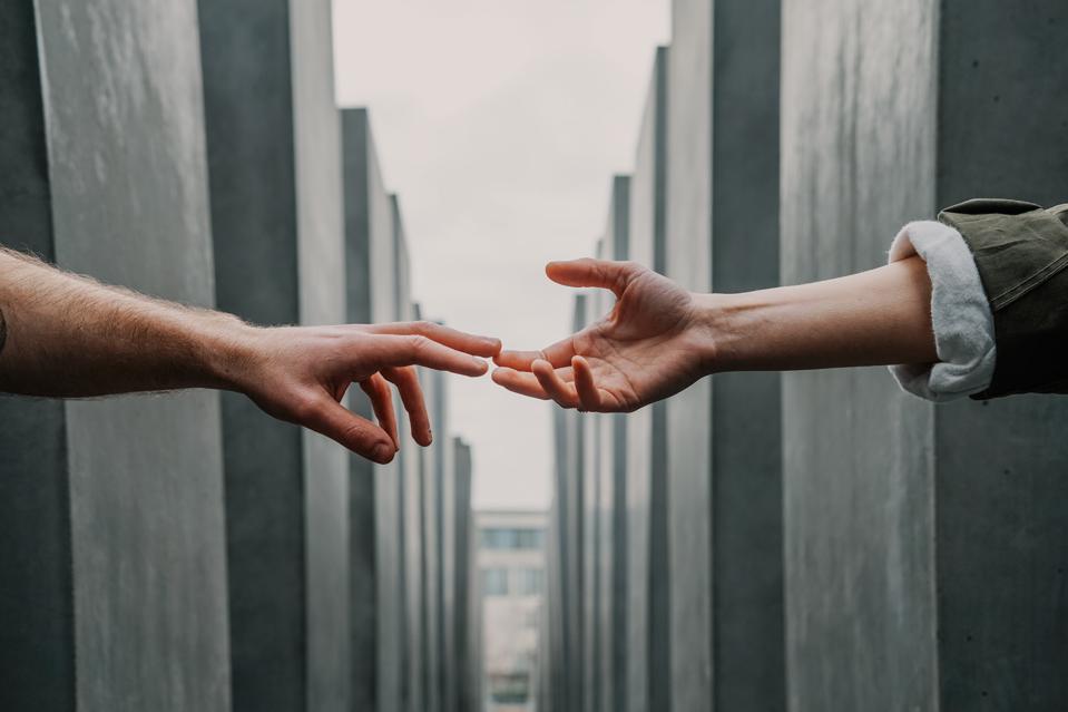 Tow hands reaching out across a set of blocks or buildings.