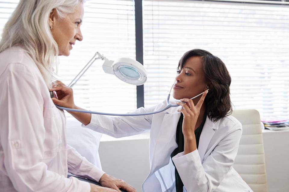 Woman Patient Having Medical Exam With Female Doctor In Office