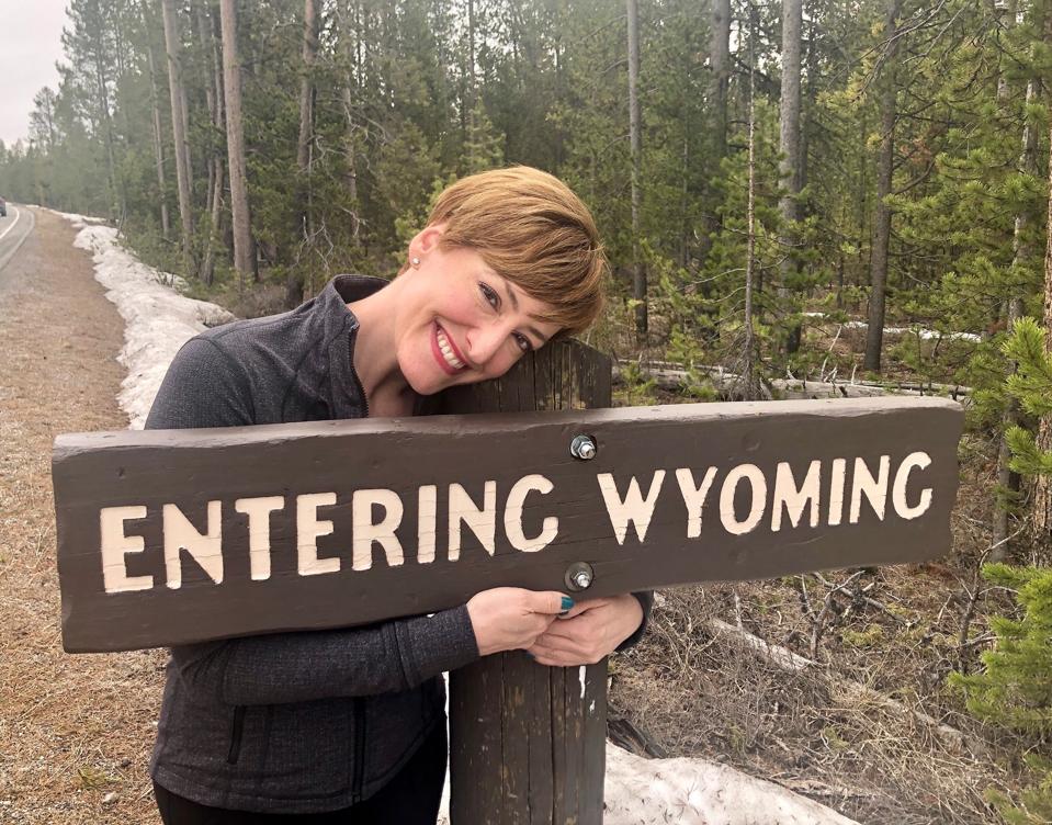 Pose panjang di depan tanda di Taman Nasional Yellowstone.