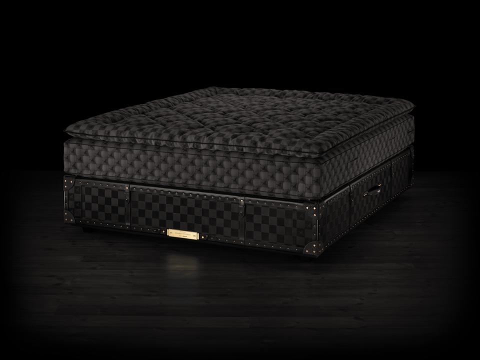 Hästens' Grand Vividus pelo Gigante Rafauli. Retratado na seleção de cores Sombra preta com coordenação de acabamento de couro queimado e bronzeado vegetal reforçado com rebites em bronze dourado, nubuck, shagreen e acabamento espelho de madeira.' Grand Vividus by Ferris Rafauli. Pictured in color selection Black Shadow with coordinating vegetable-tanned burnished leather trim reinforced with rivets in golden brass, nubuck, shagreen and mirror-finish wood borders.