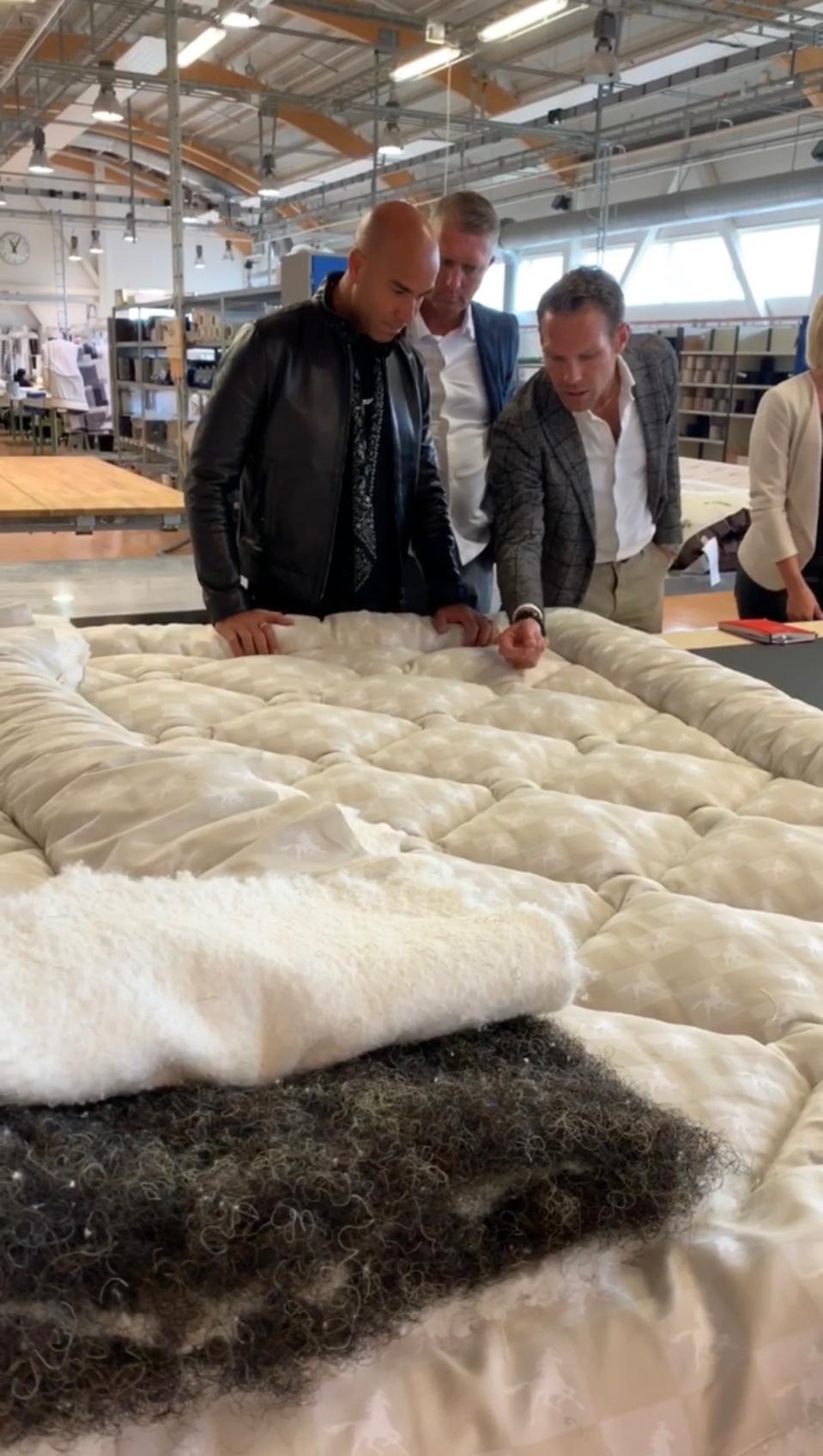 Designer Ferris Rafauli, inspecting the construction of a Grand Vividus bed with team members at the Hästens factory in Köping, Sweden.