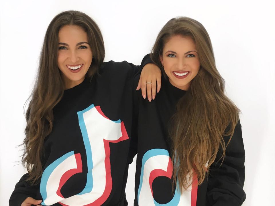 The Wilking Sisters pose in TikTok sweatshirt. 