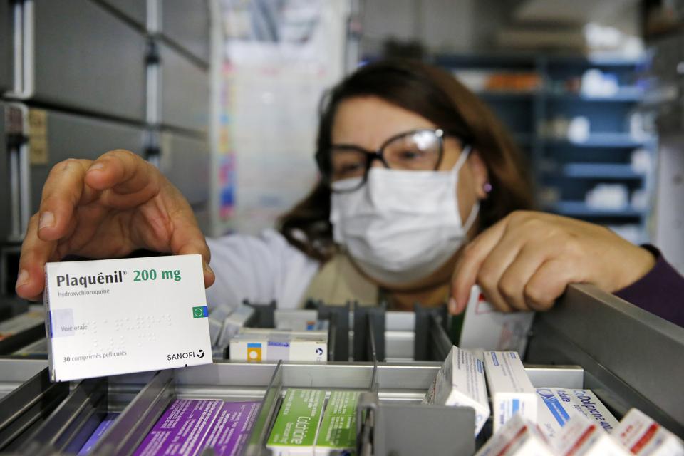 A pharmacy employee shows a box of Plaquenil (Hydroxychloroquine) on March 27, 2020 in Paris, France.