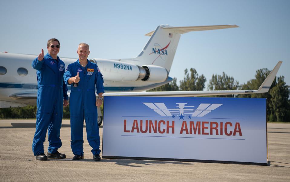 NASA astronauts Robert Behnken, left, and Douglas Hurley gives a thumbs up after arriving at the Launch and Landing Facility at NASA’s Kennedy Space Center ahead of SpaceX’s Demo-2 mission, Wednesday, May 20, 2020, in Florida. NASA’s SpaceX Demo-2 mission is the first launch with astronauts of the SpaceX Crew Dragon spacecraft and Falcon 9 rocket to the International Space Station as part of the agency’s Commercial Crew Program. The flight test will serve as an end-to-end demonstration of SpaceX’s crew transportation system. Behnken and Hurley are scheduled to launch at 4:33 p.m. EDT on Wednesday, May 27, from Launch Complex 39A at the Kennedy Space Center. A new era of human spaceflight is set to begin as American astronauts once again launch on an American rocket from American soil to low-Earth orbit for the first time since the conclusion of the Space Shuttle Program in 2011. Photo Credit: (NASA/Bill Ingalls)