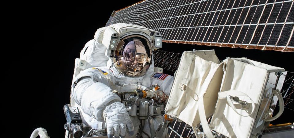 This is Scott Kelly at work on ISS maintenance with the station's solar arrays visible in the background.