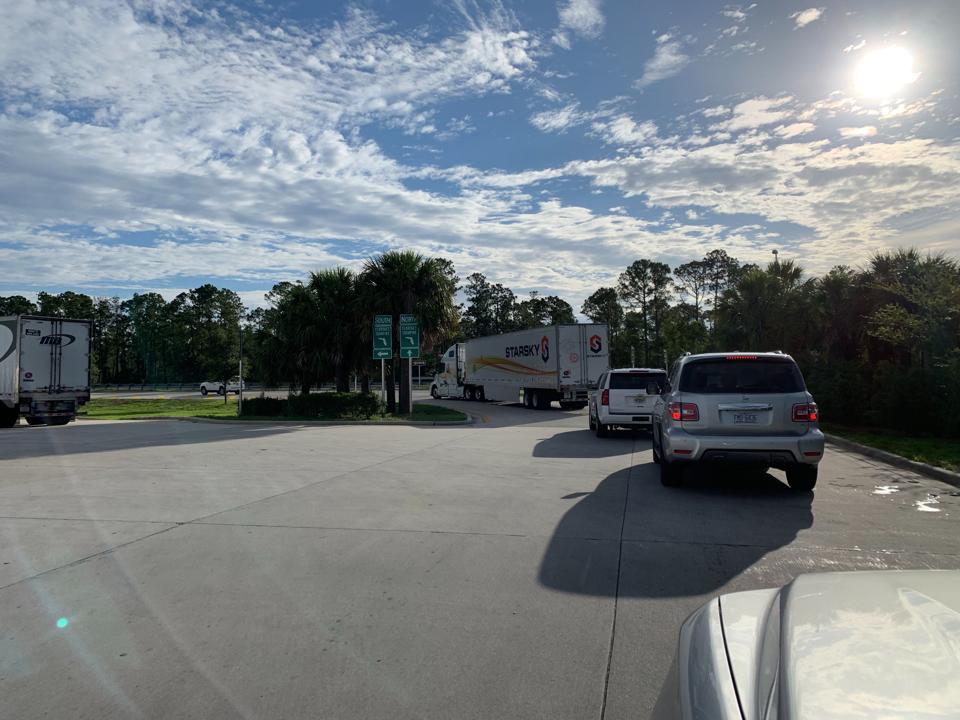 A truck with no driver followed by two SUVs heads onto the highway