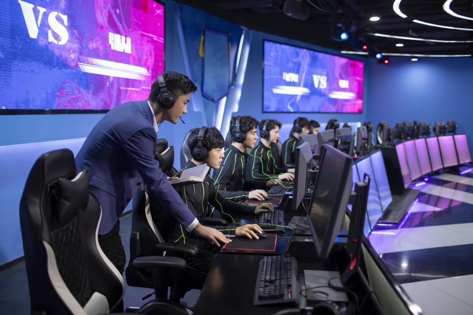 Young Chinese man coaching gamer playing esports