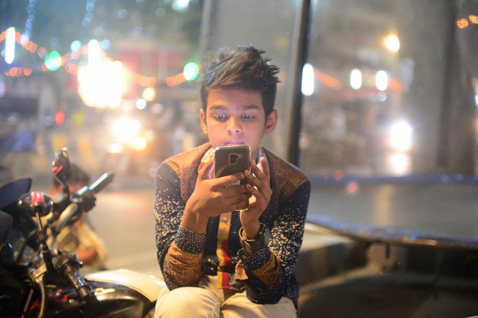 A youngster watches a video on his smartphone in Allahabad.