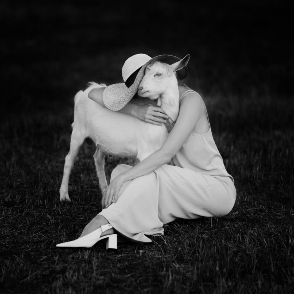 Người phụ nữ mặc áo trắng với con dê trắng