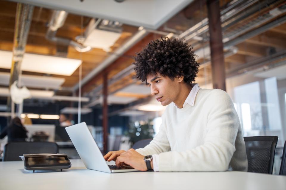 Young businessman using laptop in office