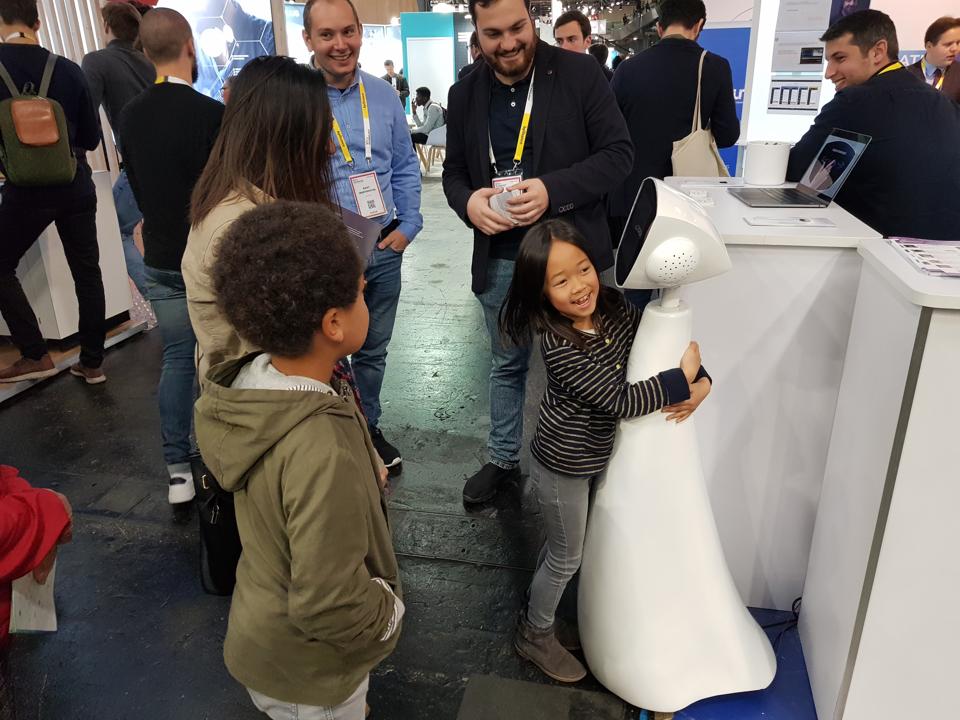 一个女孩在法国世博会上拥抱罗宾机器人。