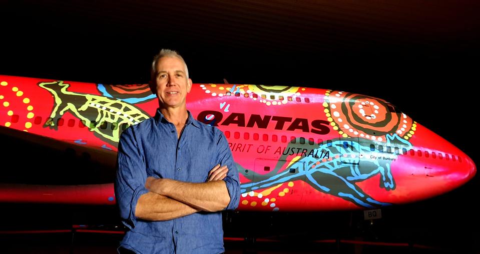 Qantas Founders Museum CEO Tony Martin with the artwork of Wunala Dreaming by Balarinji