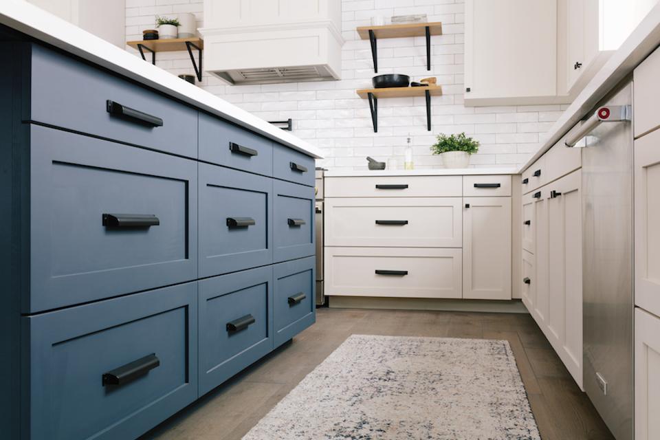 Black hardware on blue and white cabinets