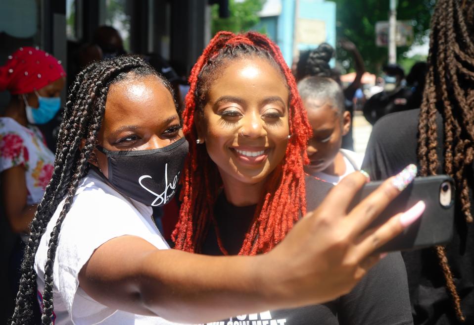 Pinky Cole, founder of Slutty Vegan, poses for a selfie with a fan.