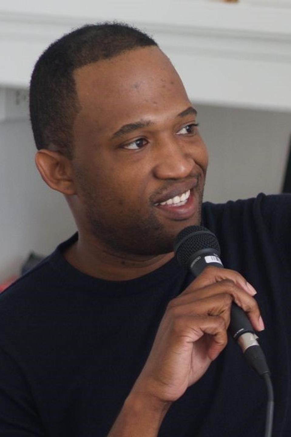Young smiling man speaking into microphone