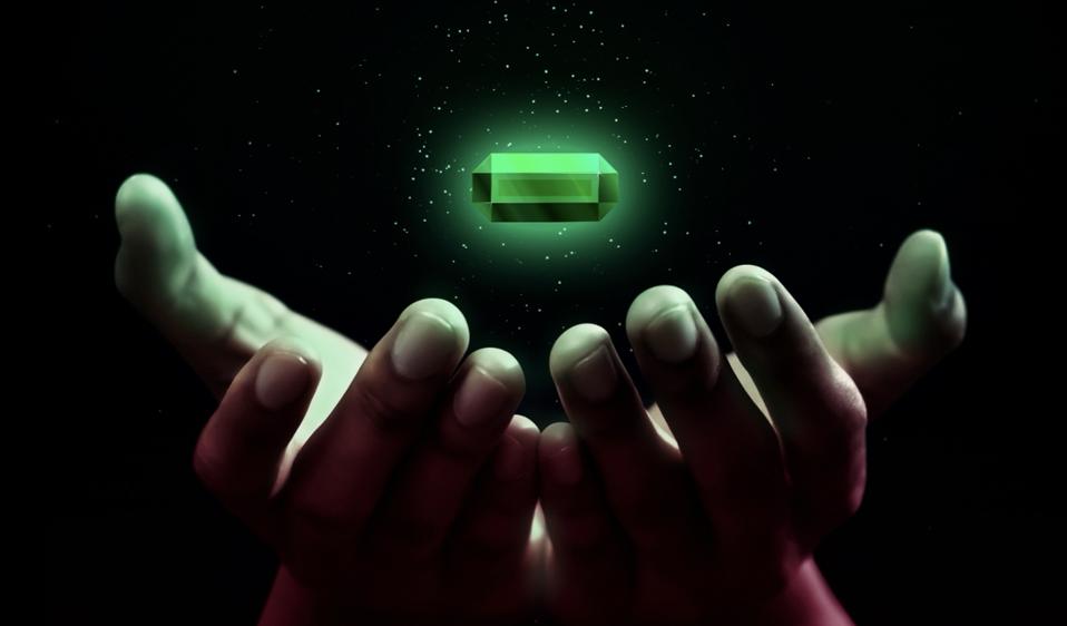 Two hands with an emerald hovering over the hand