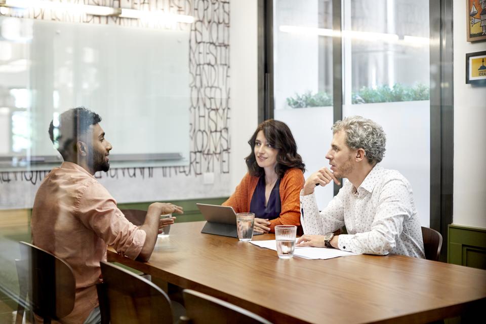 Colleagues discussing in meeting at office