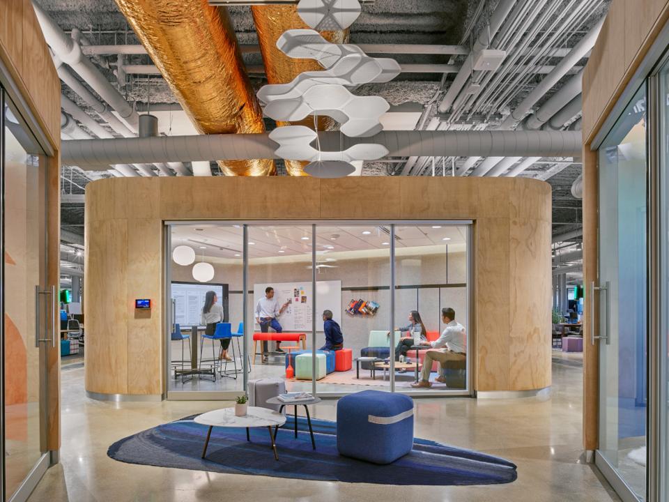 Colorful, technology-inspired conference room in modern setting with people interacting.