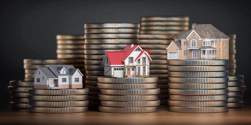 Houses of different size with different value on stacks of coins.