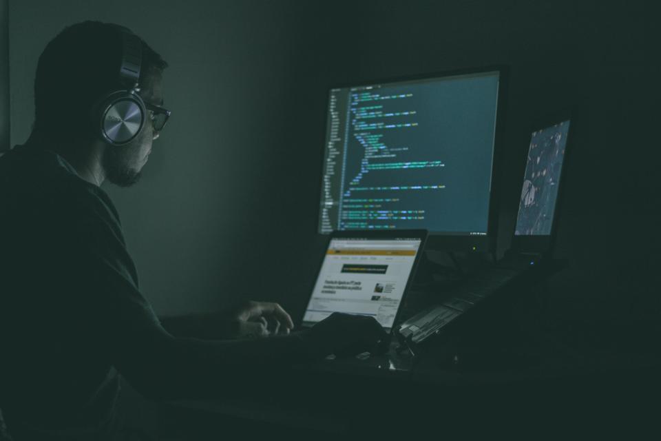Picture of person coding on laptop.
