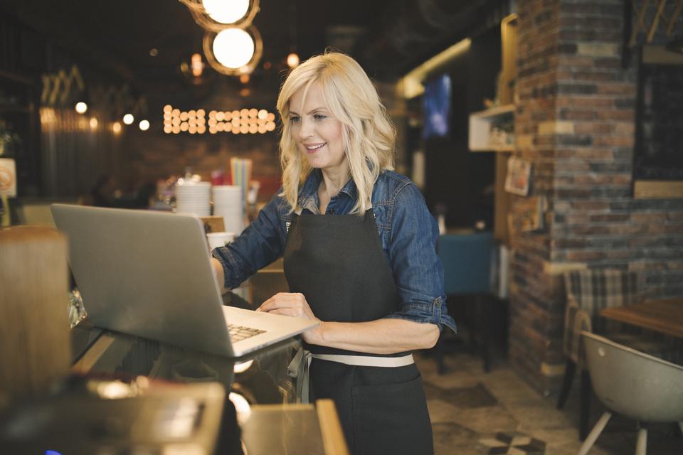 Coffee shop owner working on laptop