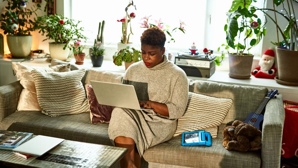 Femme Travaillant À Domicile Sur Un Canapé Avec Un Ordinateur Portable