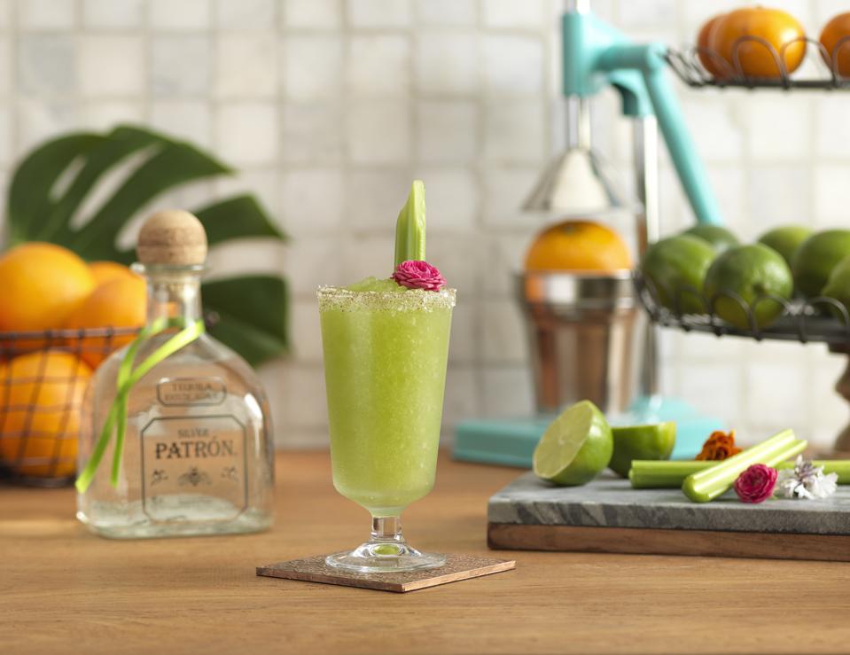 Bottle of Patron Tequila with a green margarita in a glass.