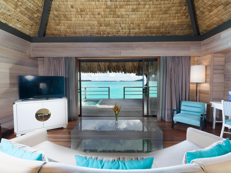 Turquoise and white contemporary furniture within an overwater villa in Bora Bora