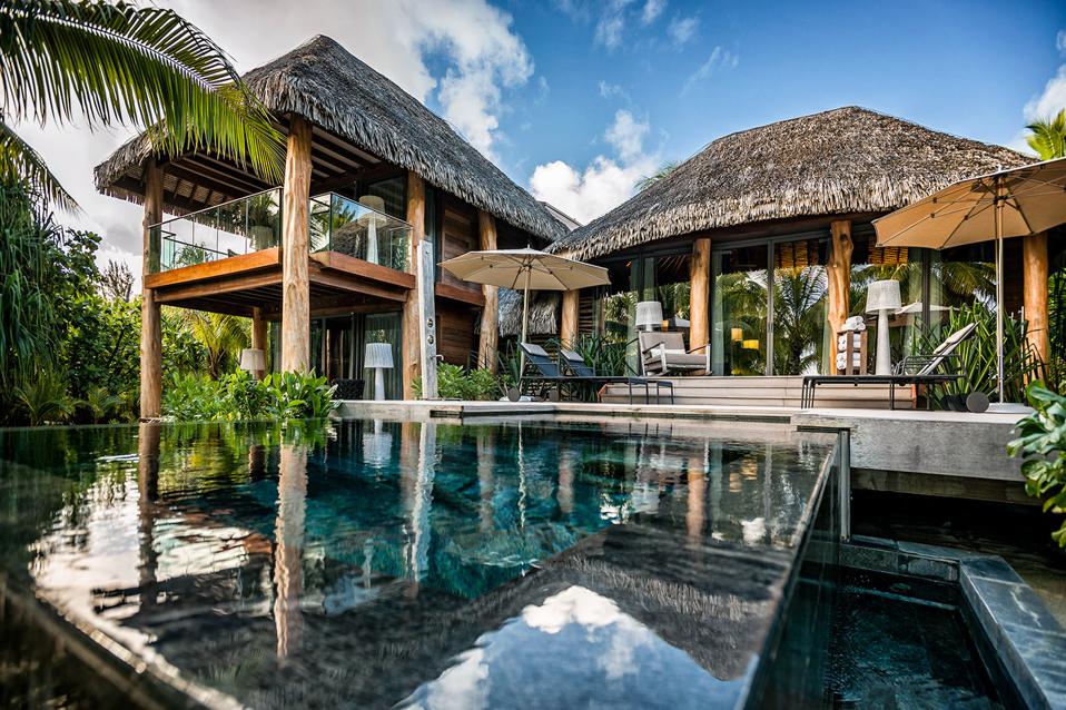 A thatched Polynesian villa and swimming pool