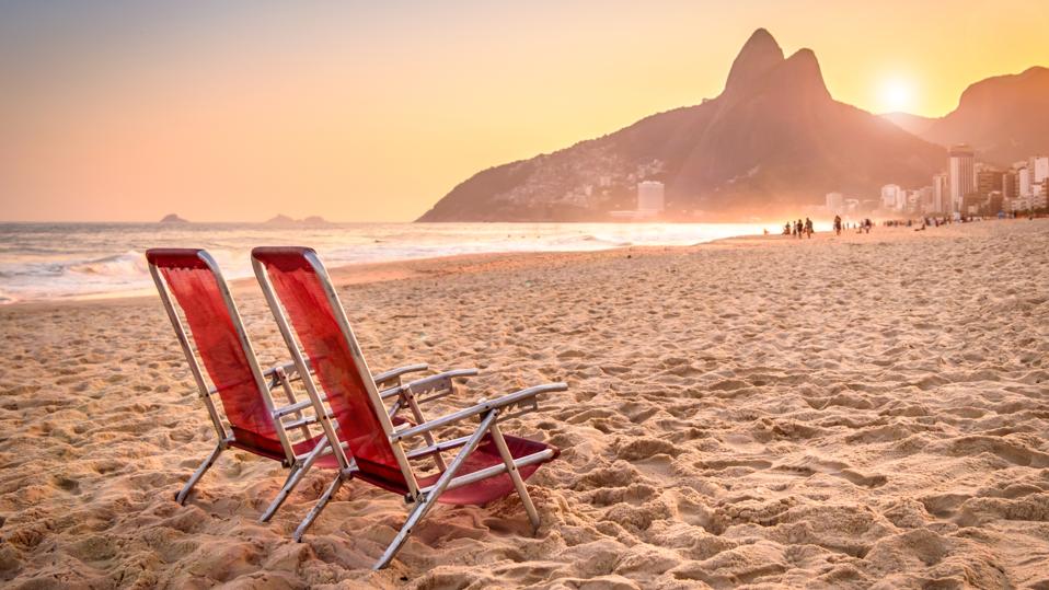 Beach deck chair against a backdrop of Two Brothers Mountain in Rio de Janeiro, Brazil