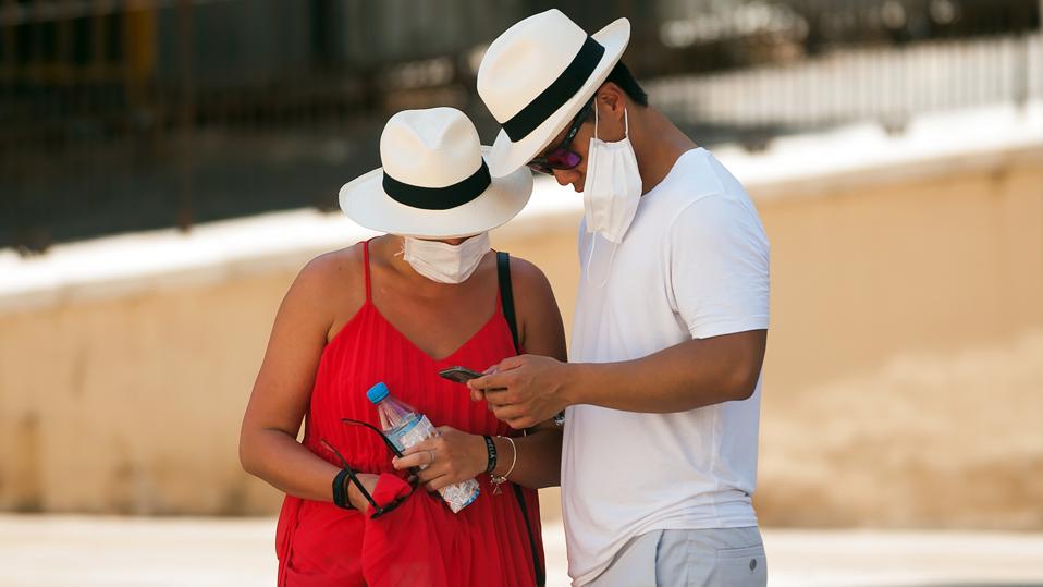 A couple of tourists wearing face masks as a precaution,...