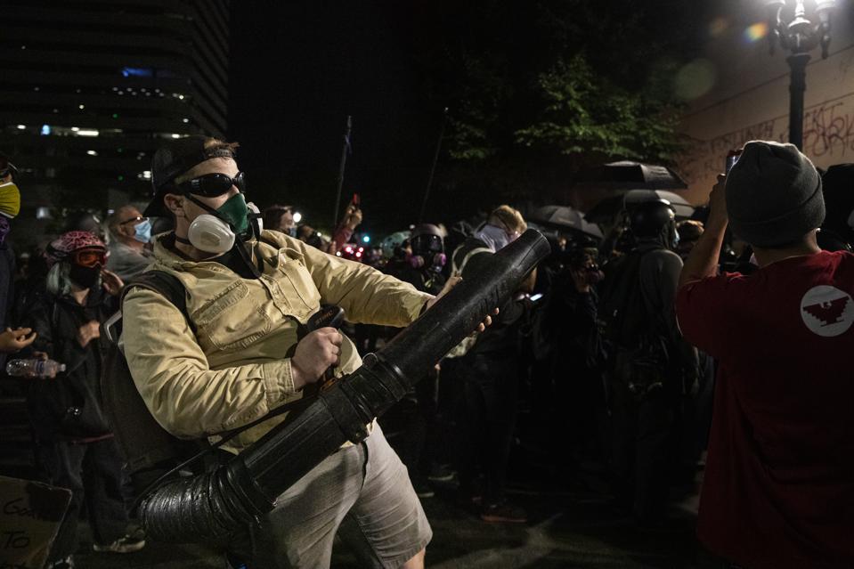 PORTLAND, OR - JULY 25: A protester uses a leaf blower to dire
