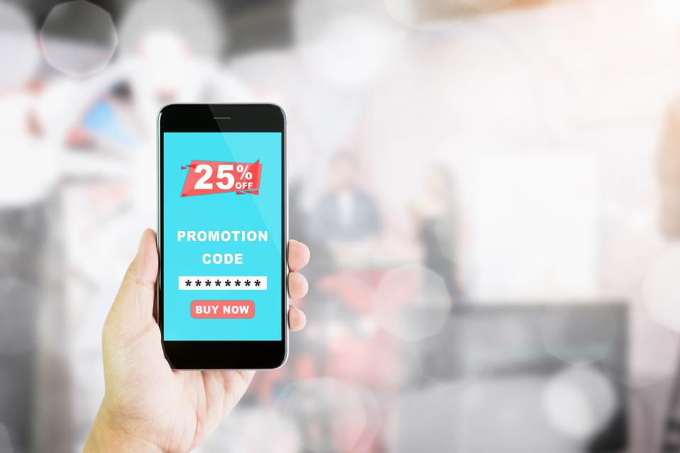 Women hold the phone to enter the code to get a discount from the store. The concept of providing marketing services on the internet for easy access to information.