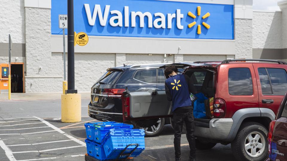 A worker delivers groceries to a customer's vehicle outside a Walmart Inc. store in Amsterdam, New York, U.S., on Friday, May 15, 2020.